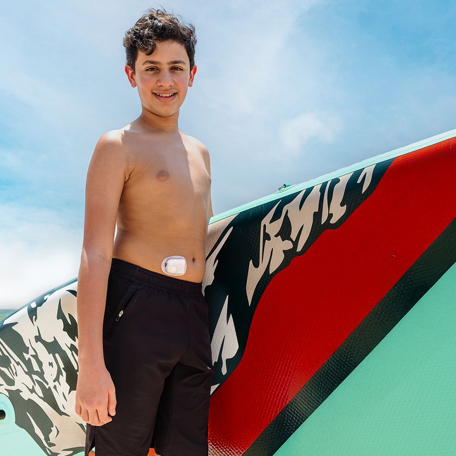 Teen with a paddleboard wearing an Omnipod pod on the beach – Omnipod video production UAE