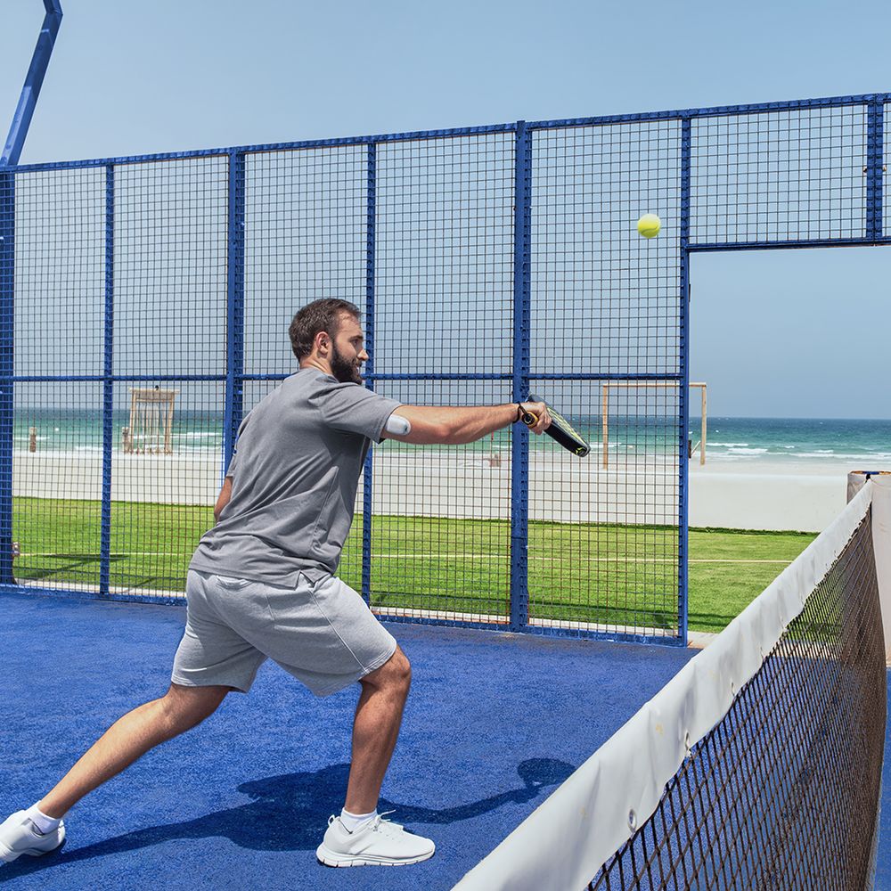 Man playing padel by the beach wearing an Omnipod pod – medtech lifestyle content Dubai