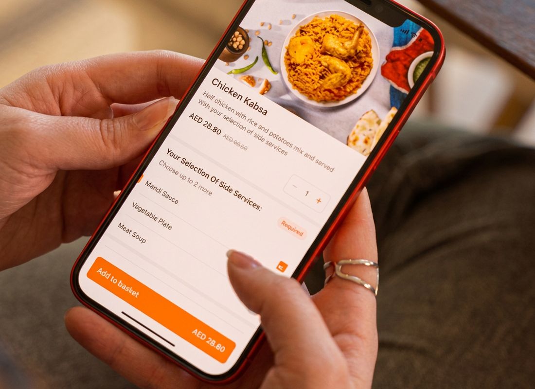 Hands ordering Chicken Kabsa on the Talabat app – food delivery advertising Dubai